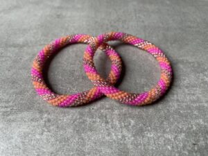 Nepal perle armbånd Nepal armbånd er en inspirerende og fascinerende smykkegenre, der vækker interessen hos smykkeentusiaster over hele verden. Disse håndlavede armbånd er kunstværker, der udstråler autenticitet, skønhed og dyb symbolik. Lad os dykke ned i den betagende verden af Nepal armbånd og udforske, hvad der gør dem så unikke og eftertragtede. Hvert Nepal armbånd er unikt, og det er netop denne individualitet, der appellerer til mange. Armbåndene er ofte skabt af dygtige nepalesiske håndværkere, der gennem generationer har forfinet deres teknikker til at skabe smykker af høj kvalitet. Disse håndværkere bruger traditionelle metoder, som har været en del af Nepals kultur og historie i århundreder. Processen er omhyggelig og kræver en stor grad af præcision og tålmodighed, hvilket gør hvert armbånd til en kærlighedsfyldt skabelse. Nepal armbånd er kendt for deres farverige og levende design. De er ofte dekoreret med perler, ædelstene, træ, metal eller andre naturlige materialer, hvilket giver dem et unikt udseende. Hvert enkelt element, der anvendes i armbåndene, er udvalgt omhyggeligt for at skabe en harmonisk kombination af farver og teksturer. Disse elementer er ofte inspireret af Nepals rige natur og kultur, hvilket giver armbåndene en autentisk følelse og en stærk forbindelse til landet. Symbolik spiller også en vigtig rolle i Nepal armbåndenes popularitet. Mange af armbåndene har indgraverede mønstre eller symboler, der repræsenterer vigtige aspekter af Nepals traditioner og spiritualitet. Disse symboler kan have betydning for held, lykke, kærlighed, beskyttelse eller en dybere forbindelse til naturen. At bære et Nepal armbånd kan derfor have en dybere betydning for bæreren og kan fungere som en påmindelse om deres forbindelse til Nepals rige arv. Nepal armbånd er ikke kun smukke smykker, men de har også en stærk social og kulturel betydning. Mange af disse smykker er håndlavede af kvinder, der er en del af samfundet i landområderne i Nepal. Produktionen af armbåndene giver disse kvinder mulighed for at skabe en bæredygtig indkomst, forbedre deres levevilkår og styrke deres selvstændighed. Når du køber et Nepal armbånd, bidrager du derfor til at støtte en positiv social indvirkning og bevare traditionelle håndværksmæssige metoder. Udover deres kulturelle og sociale betydning er Nepal armbånd også en favorit blandt modebevidste enkeltpersoner, der ønsker at tilføje en unik og autentisk touch til deres stil. Disse armbånd kan styles på utallige måder, uanset om du ønsker at skabe et bohemeinspireret look, en farverig festlig stil eller en subtil og elegant kombination. Der er et Nepal armbånd til enhver lejlighed og enhver personlig præference. I det store udvalg af smykker, der findes i dagens marked, skiller Nepal armbånd sig ud som en særlig perle. Deres håndlavede karakter, farverige design, dybe symbolik og sociale indvirkning gør dem til mere end bare smykker - de er en form for kunst og kultur, der fortæller historien om Nepal og dets folk. Ved at bære et Nepal armbånd, bærer du også med dig en del af dette rige og inspirerende land. Så uanset om du leder efter en meningsfuld gave eller ønsker at berige din egen smykkesamling, vil et Nepal armbånd være et mindeværdigt og værdsat valg.