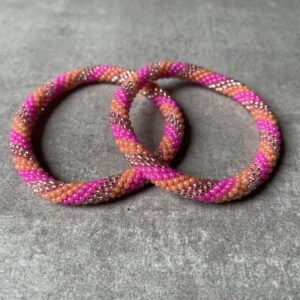 Nepal perle armbånd Nepal armbånd er en inspirerende og fascinerende smykkegenre, der vækker interessen hos smykkeentusiaster over hele verden. Disse håndlavede armbånd er kunstværker, der udstråler autenticitet, skønhed og dyb symbolik. Lad os dykke ned i den betagende verden af Nepal armbånd og udforske, hvad der gør dem så unikke og eftertragtede. Hvert Nepal armbånd er unikt, og det er netop denne individualitet, der appellerer til mange. Armbåndene er ofte skabt af dygtige nepalesiske håndværkere, der gennem generationer har forfinet deres teknikker til at skabe smykker af høj kvalitet. Disse håndværkere bruger traditionelle metoder, som har været en del af Nepals kultur og historie i århundreder. Processen er omhyggelig og kræver en stor grad af præcision og tålmodighed, hvilket gør hvert armbånd til en kærlighedsfyldt skabelse. Nepal armbånd er kendt for deres farverige og levende design. De er ofte dekoreret med perler, ædelstene, træ, metal eller andre naturlige materialer, hvilket giver dem et unikt udseende. Hvert enkelt element, der anvendes i armbåndene, er udvalgt omhyggeligt for at skabe en harmonisk kombination af farver og teksturer. Disse elementer er ofte inspireret af Nepals rige natur og kultur, hvilket giver armbåndene en autentisk følelse og en stærk forbindelse til landet. Symbolik spiller også en vigtig rolle i Nepal armbåndenes popularitet. Mange af armbåndene har indgraverede mønstre eller symboler, der repræsenterer vigtige aspekter af Nepals traditioner og spiritualitet. Disse symboler kan have betydning for held, lykke, kærlighed, beskyttelse eller en dybere forbindelse til naturen. At bære et Nepal armbånd kan derfor have en dybere betydning for bæreren og kan fungere som en påmindelse om deres forbindelse til Nepals rige arv. Nepal armbånd er ikke kun smukke smykker, men de har også en stærk social og kulturel betydning. Mange af disse smykker er håndlavede af kvinder, der er en del af samfundet i landområderne i Nepal. Produktionen af armbåndene giver disse kvinder mulighed for at skabe en bæredygtig indkomst, forbedre deres levevilkår og styrke deres selvstændighed. Når du køber et Nepal armbånd, bidrager du derfor til at støtte en positiv social indvirkning og bevare traditionelle håndværksmæssige metoder. Udover deres kulturelle og sociale betydning er Nepal armbånd også en favorit blandt modebevidste enkeltpersoner, der ønsker at tilføje en unik og autentisk touch til deres stil. Disse armbånd kan styles på utallige måder, uanset om du ønsker at skabe et bohemeinspireret look, en farverig festlig stil eller en subtil og elegant kombination. Der er et Nepal armbånd til enhver lejlighed og enhver personlig præference. I det store udvalg af smykker, der findes i dagens marked, skiller Nepal armbånd sig ud som en særlig perle. Deres håndlavede karakter, farverige design, dybe symbolik og sociale indvirkning gør dem til mere end bare smykker - de er en form for kunst og kultur, der fortæller historien om Nepal og dets folk. Ved at bære et Nepal armbånd, bærer du også med dig en del af dette rige og inspirerende land. Så uanset om du leder efter en meningsfuld gave eller ønsker at berige din egen smykkesamling, vil et Nepal armbånd være et mindeværdigt og værdsat valg.