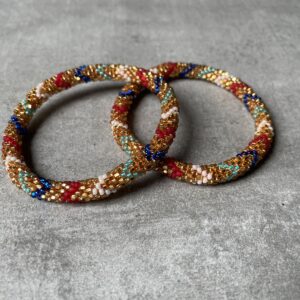 Nepal perle armbånd Nepal armbånd er en inspirerende og fascinerende smykkegenre, der vækker interessen hos smykkeentusiaster over hele verden. Disse håndlavede armbånd er kunstværker, der udstråler autenticitet, skønhed og dyb symbolik. Lad os dykke ned i den betagende verden af Nepal armbånd og udforske, hvad der gør dem så unikke og eftertragtede. Hvert Nepal armbånd er unikt, og det er netop denne individualitet, der appellerer til mange. Armbåndene er ofte skabt af dygtige nepalesiske håndværkere, der gennem generationer har forfinet deres teknikker til at skabe smykker af høj kvalitet. Disse håndværkere bruger traditionelle metoder, som har været en del af Nepals kultur og historie i århundreder. Processen er omhyggelig og kræver en stor grad af præcision og tålmodighed, hvilket gør hvert armbånd til en kærlighedsfyldt skabelse. Nepal armbånd er kendt for deres farverige og levende design. De er ofte dekoreret med perler, ædelstene, træ, metal eller andre naturlige materialer, hvilket giver dem et unikt udseende. Hvert enkelt element, der anvendes i armbåndene, er udvalgt omhyggeligt for at skabe en harmonisk kombination af farver og teksturer. Disse elementer er ofte inspireret af Nepals rige natur og kultur, hvilket giver armbåndene en autentisk følelse og en stærk forbindelse til landet. Symbolik spiller også en vigtig rolle i Nepal armbåndenes popularitet. Mange af armbåndene har indgraverede mønstre eller symboler, der repræsenterer vigtige aspekter af Nepals traditioner og spiritualitet. Disse symboler kan have betydning for held, lykke, kærlighed, beskyttelse eller en dybere forbindelse til naturen. At bære et Nepal armbånd kan derfor have en dybere betydning for bæreren og kan fungere som en påmindelse om deres forbindelse til Nepals rige arv. Nepal armbånd er ikke kun smukke smykker, men de har også en stærk social og kulturel betydning. Mange af disse smykker er håndlavede af kvinder, der er en del af samfundet i landområderne i Nepal. Produktionen af armbåndene giver disse kvinder mulighed for at skabe en bæredygtig indkomst, forbedre deres levevilkår og styrke deres selvstændighed. Når du køber et Nepal armbånd, bidrager du derfor til at støtte en positiv social indvirkning og bevare traditionelle håndværksmæssige metoder. Udover deres kulturelle og sociale betydning er Nepal armbånd også en favorit blandt modebevidste enkeltpersoner, der ønsker at tilføje en unik og autentisk touch til deres stil. Disse armbånd kan styles på utallige måder, uanset om du ønsker at skabe et bohemeinspireret look, en farverig festlig stil eller en subtil og elegant kombination. Der er et Nepal armbånd til enhver lejlighed og enhver personlig præference. I det store udvalg af smykker, der findes i dagens marked, skiller Nepal armbånd sig ud som en særlig perle. Deres håndlavede karakter, farverige design, dybe symbolik og sociale indvirkning gør dem til mere end bare smykker - de er en form for kunst og kultur, der fortæller historien om Nepal og dets folk. Ved at bære et Nepal armbånd, bærer du også med dig en del af dette rige og inspirerende land. Så uanset om du leder efter en meningsfuld gave eller ønsker at berige din egen smykkesamling, vil et Nepal armbånd være et mindeværdigt og værdsat valg.